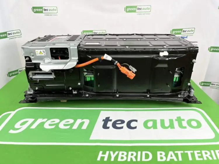 Large EV battery pack on a green display surface with orange high-voltage connector visible