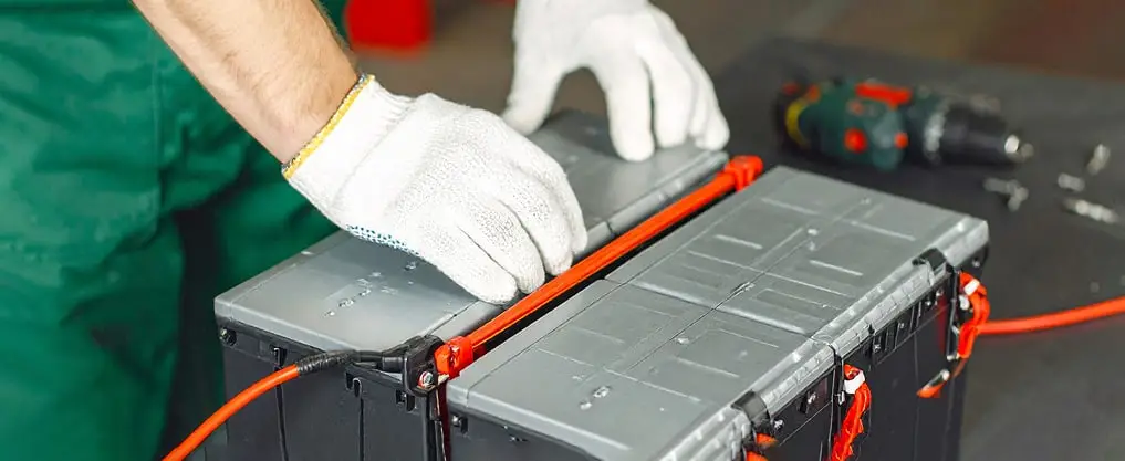 Worker handling car battery