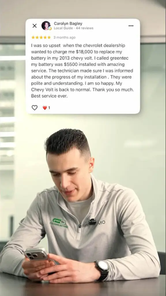 Young man in a light gray polo sits at a desk, looking at his phone, with a customer testimonial bubble above him praising service.