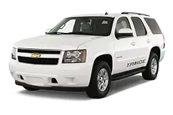 Front-left view of a white Chevrolet Tahoe SUV showing its grille, headlights, and wheel.