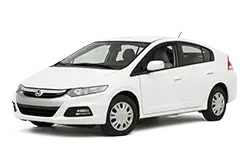 White four-door sedan shown in a three-quarter front view, featuring black trim and hubcaps.