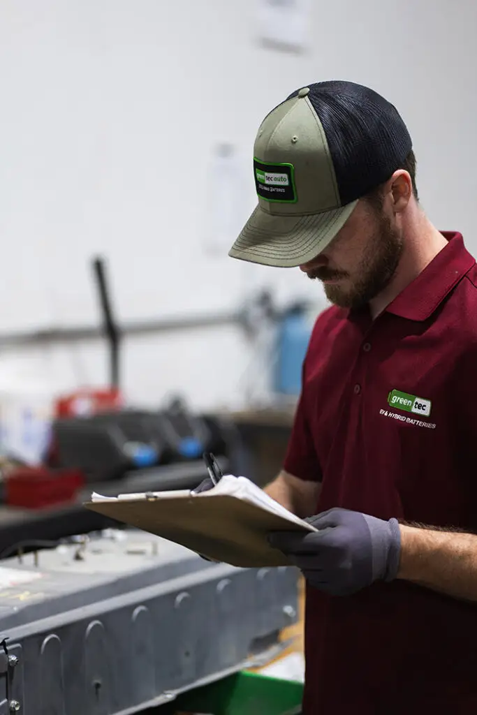 Greentec Auto Worker Checking Battery