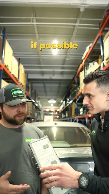 Two workers in a warehouse inspect a clipboard beside a car, with tall shelves and overhead lights; caption reads 'if possible'.