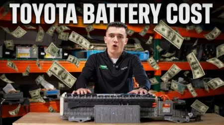 Video thumbnail: man at a workbench with car battery parts, money flying around, and bold 'TOYOTA BATTERY COST' text above — signaling a cost-focused discussion.